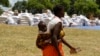 Une femme avec un enfant au dos est parmi les personnes touchées par la sécheresse en Angola, au Lesotho, an Malawi, et au Zimbabwe, 7 mars 2013. 