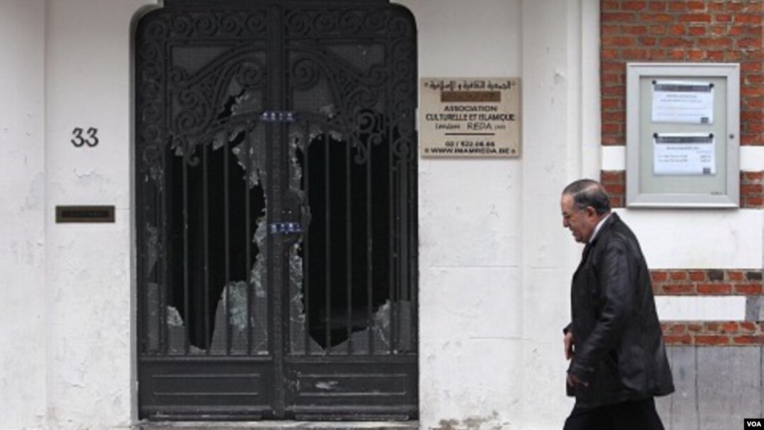 Seorang pria melewati pintu masjid Reda yang rusak di Brussels, Belgia (13/3).