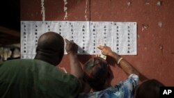 People check for their names on the voters registration list during the presidential elections in Agulu, Nigeria, Saturday, Feb. 25, 2023. 