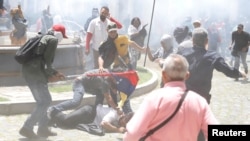 Partidarios del gobierno atacan a una persona frente a la Asamblea Nacional de Venezuela en Caracas, el miércoles, 5 de julio de 2017.