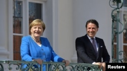 German Chancellor Angela Merkel welcomes Italian Prime Minister Giuseppe Conte before a meeting at the German governmental guest house in Meseberg, outside Berlin, Germany, July 13, 2020. 