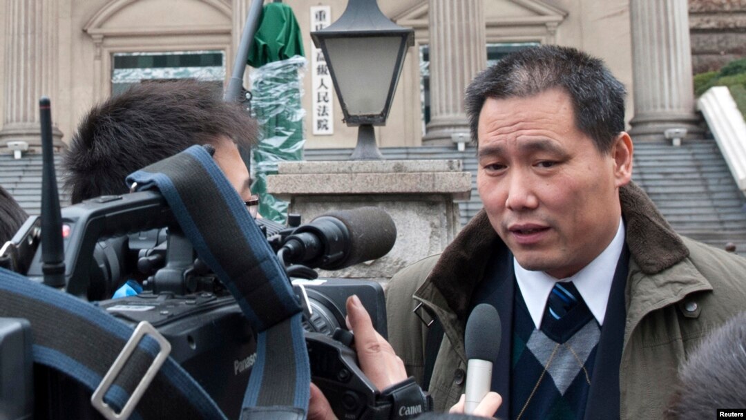 FILE - Chinese lawyer Pu Zhiqiang (R) speaks to journalists outside a courthouse in Chongqing municipality.