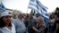 Protesters holding national flags take part in an anti-austerity rally in front of the parliament in Athens, Greece, June 17, 2015.