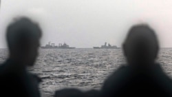 This handout photo taken Feb. 13, 2025, and released by The Australian Defence Force shows sailors aboard the Royal Australian Navy ship HMAS Arunta looking at the People's Liberation Army-Navy vessels in the Tasman Sea. 