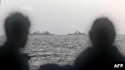 This handout photo taken Feb. 13, 2025, and released by The Australian Defence Force shows sailors aboard the Royal Australian Navy ship HMAS Arunta looking at the People's Liberation Army-Navy vessels in the Tasman Sea. 