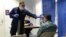 U.S. Coast Guard Health Technician Nathan Wallenmeyer (L) and Customs Border Protection (CBP) Supervisor Sam Ko conduct pre-screening measures on a passenger arriving from Sierra Leone at O'Hare International Airport's Terminal 5 in Chicago, Illinois, Oct. 16, 2014.