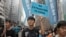 FILE - Protesters with placards and flags against an extradition law march toward the government headquarters in Hong Kong, March 31, 2019.