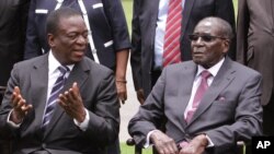 Emmerson Mnangagwa, à gauche, le vice-président du Zimbabwe discute avec le président zimbabwéen Robert Mugabe après la cérémonie de prestation de serment à State House à Harare, le 12 décembre 2014.