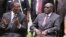 FILE: Emmerson Mnangagwa, left, Vice President of Zimbabwe chats with Zimbabwean President Robert Mugabe after the swearing in ceremony at State House in Harare, Dec, 12, 2014. 