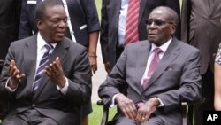 FILE: Emmerson Mnangagwa, left, Vice President of Zimbabwe chats with Zimbabwean President Robert Mugabe after the swearing in ceremony at State House in Harare, Dec, 12, 2014. 