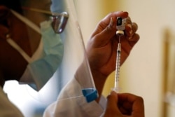 FILE - A Walgreens pharmacist prepares a syringe with COVID-19 vaccine in Coral Gables, Fla., Jan. 12, 2021.