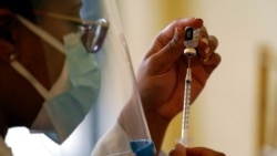 FILE - A Walgreens pharmacist prepares a syringe with COVID-19 vaccine in Coral Gables, Fla., Jan. 12, 2021. Scientists are seeing signs that some mutations of the virus that causes COVID-19 may modestly curb the effectiveness of current vaccines.