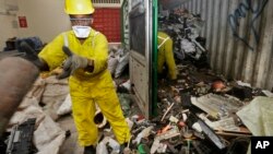 FILE - Workers unload and sort through a container full of electronic waste that was collected from a Nairobi slum and brought in for recycling, at the East African Compliant Recycling facility in Machakos, in Kenya, Aug. 18. 2014.