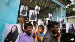 FILE - Villagers hold placards featuring US Vice President-elect Kamala Harris outside a Hindu temple in Thulasendrapuram, the hometown of Harris' maternal grandfather, south of Chennai, Tamil Nadu state, India, Jan. 20, 2021.