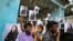 FILE - Villagers hold placards featuring US Vice President-elect Kamala Harris outside a Hindu temple in Thulasendrapuram, the hometown of Harris' maternal grandfather, south of Chennai, Tamil Nadu state, India, Jan. 20, 2021.