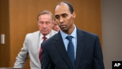 FILE - Former Minneapolis police officer Mohamed Noor walks to the podium at Hennepin County District Court in Minneapolis. The Minnesota Supreme Court has reversed the third-degree murder conviction of Noor who fatally shot an Australian woman in 2017.