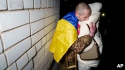 Ukrainian serviceman Yevhen Liashenko hugs his wife, Kateryna, after returning from captivity during a prisoner exchange between Russia and Ukraine, in Ukraine, Dec. 30, 2024.