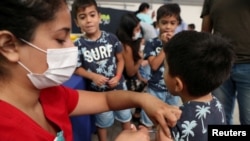 FILE PHOTO: A child receives a vaccination as part of the start of the seasonal flu vaccination campaign as a preventive measure due to the outbreak of coronavirus disease (COVID-19), in Santiago, Chile March 16, 2020. REUTERS/Ivan Alvarado/File Photo