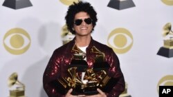 Bruno Mars poses in the press room with his awards at the 60th annual Grammy Awards at Madison Square Garden on Sunday, Jan. 28, 2018, in New York. 