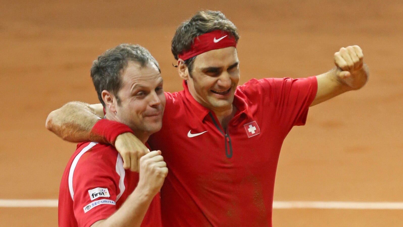 Swiss coach Severin Luthi (L) and Switzerland's Roger Federer celebrate after Federer defeated France's Richard Gasquet in the Davis Cup final in Lille, northern France, Nov. 23, 2014.