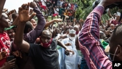 Guinean opposition leader Cellou Dalein Diallo, center, in white, walks with supporters at his headquarters in Conakry, Guinea, Oct. 19, 2020. 