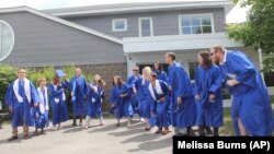 The Class of 2021 – all 13 of them – were eyeing a trip to Greece, or maybe South Korea, but they wound up going nowhere. The students decided to donate $5,000 to help out struggling neighbors after the coronavirus pandemic changed everything. (Melissa Burns via AP)