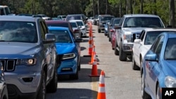 Motorists wait in long lines for fuel at a newly opened depot after Hurricane Milton,, Oct. 12, 2024, in Plant City, Fla.