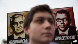 Manifestantes sostienen una pancarta que muestra la imagen del presidente de Guatemala, Otto Pérez Molina, a la izquierda, y Manuel Baldizon, Ciudad de Guatemala, el 13 de julio de 2015. 