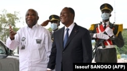 Le président de la Côte d'Ivoire Alassane Ouattara (au centre) pose avec l'ancien président Laurent Gbagbo (à gauche) au palais présidentiel d'Abidjan, le 27 juillet 2021.