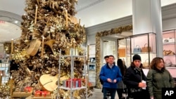 Unos clientes pasan junto a un árbol de Navidad en la tienda Bergdorf Goodman el 24 de noviembre de 2024, en Nueva York. 