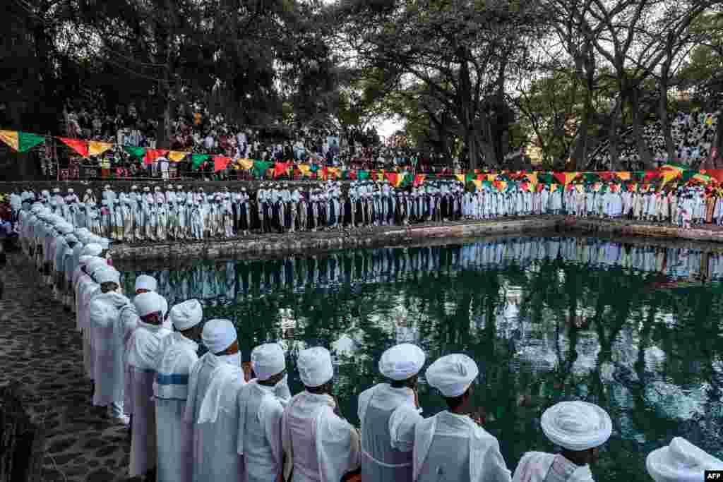 Ethiopian Orthodox Christian priests stand next to a pool during the celebration of Timkat, the Ethiopian Epiphany, in Fasilides Bath, in the city of Gondar.