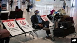 Beberapa orang yang baru tiba di bandara Heathrow, London, pada hari pertama pemberlakukan karantina 2 minggu bagi pendatang di Inggris, Senin (8/6).