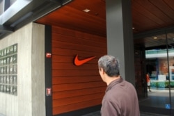 FILE - A man passes a Nike store in Los Angeles, California. (Photo by Diaa Bekheet)