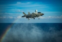 A U.S. Marines F-35B Lightning II fighter aircraft prepares to land on the flight deck in the South China Sea.