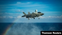 A U.S. Marines F-35B Lightning II fighter aircraft prepares to land on the flight deck in the South China Sea.