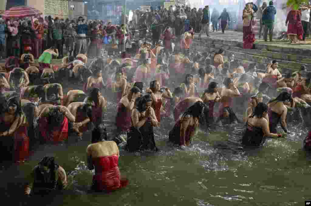 Devotees take holy dips in the Sali river during Madhav Narayan festival in Sankhu, northeast of Kathmandu, Nepal.