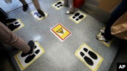 Social distancing stickers are viewed in an elevator at a shopping building Monday, Sept. 28, 2020, in Tokyo.