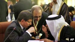 Turkey's FM Ahmet Davutoglu (L) confers with United Arab Emirates' (UAE) FM Sheikh Abdullah bin Zayed al-Nahyan during the Friends of Syria Conference in Tunis, February 24, 2012