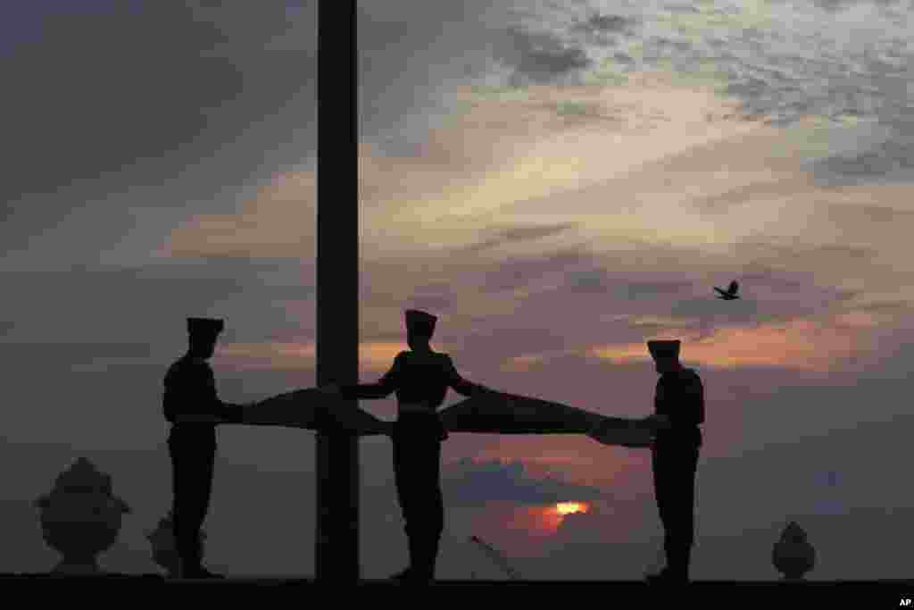 Sri Lankan Army soldiers lower the national flag as the sun sets in Colombo.