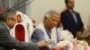 FILE -Nobel laureate Muhammad Yunus signs a document after taking the oath of office as the head of Bangladesh's interim government, in Dhaka, Bangladesh, Aug. 8, 2024.