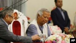 FILE -Nobel laureate Muhammad Yunus signs a document after taking the oath of office as the head of Bangladesh's interim government, in Dhaka, Bangladesh, Aug. 8, 2024.