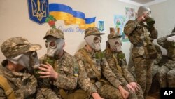 Cadetes practican ponerse máscaras de gas durante una lección en Kiev, Ucrania, el martes 6 de junio de 2023.