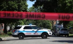 FILE - Police tape marks off a Chicago street as officers investigate the scene of a fatal shooting in the city's south side, June 15, 2021.