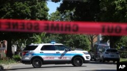 FILE - Police tape marks off a Chicago street as officers investigate the scene of a fatal shooting in the city's south side, June 15, 2021. 