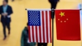 This file picture taken on November 6, 2018 shows a Chinese and US flag at a booth during the first China International Import Expo in Shanghai. - The US public's opinion of China has plummeted amid a surge in strategic and trade tensions in recent years