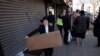 FILE - A boy carries a box of matzos for Passover that he picked up from his synagogue in the Brooklyn borough of New York, March 26, 2020. The coronavirus has forced Jewish families to limit the celebratory Passover meals known as Seders.