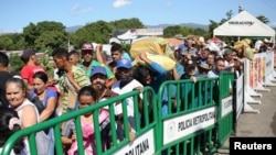 Orang-orang menyeberangi jembatan Simon Bolivar di perbatasan Kolombia-Venezuela yang dibuka sebagian di San Antonio del Tachira, Venezuela, 8 Juni 2019. (Foto: REUTERS/Carlos Eduardo Ramirez)