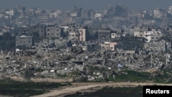 An Israeli flag flutters amid ruins in the Gaza Strip as the conflict between Israel and the Palestinian Islamist group Hamas continues, as seen from Israel, Feb. 13, 2024.