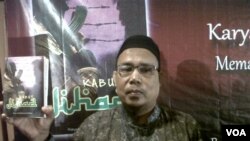 Terpidana teroris Khairul Gazali memegang novelnya 'Kabut Jihad' yang ditulis di penjara. (foto: Andylala Waluyo)