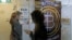 FILE - People use a bitcoin ATM in Hong Kong, Dec. 8, 2017.